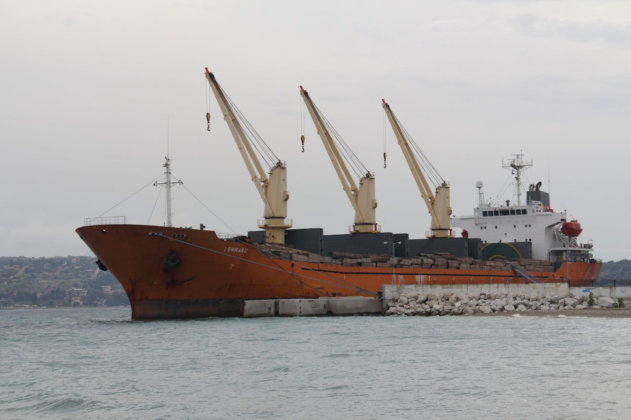 services-02 Cargo ship with cranes docked at a port, showcasing maritime logistics.